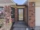 Close-up view of the front door with brick accents, a window, and decorative landscaping at 1739 Wellesley Commons # 48A, Indianapolis, IN 46219