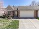 Charming brick home featuring an attached two-car garage, a well-manicured lawn, and a lovely flower bed at 1739 Wellesley Commons # 48A, Indianapolis, IN 46219