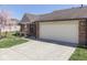 Charming brick home featuring an attached two-car garage, a well-manicured lawn, and a lovely flower bed at 1739 Wellesley Commons # 48A, Indianapolis, IN 46219