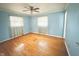 A light blue bedroom with hardwood floors, natural light, and ceiling fan at 1761 Country Lane Dr, Greenfield, IN 46140