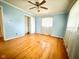 Light blue bedroom featuring hardwood floors, ceiling fan, and closet at 1761 Country Lane Dr, Greenfield, IN 46140