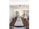 Elegant dining room with a large wooden table, modern lighting, and access to the kitchen and stairway at 1802 Bellefontaine St, Indianapolis, IN 46202