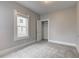 This bedroom features neutral walls, carpet flooring, a closet, and a bright window at 1911 Wilcox St, Indianapolis, IN 46222