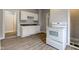 This kitchen features white appliances and cabinets with vinyl flooring at 1911 Wilcox St, Indianapolis, IN 46222