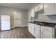 This kitchen is equipped with light cabinets, dark countertops, and wood-look vinyl flooring at 1911 Wilcox St, Indianapolis, IN 46222