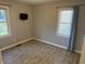 Bedroom with wood floor, two windows, and a wall-mounted TV on the grey painted walls at 1952 N Colorado Ave, Indianapolis, IN 46218