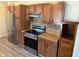 Kitchen featuring stainless steel appliances, warm wood cabinets, tile backsplash, and granite countertops at 1952 N Colorado Ave, Indianapolis, IN 46218