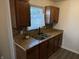 Kitchen sink area featuring granite countertops, stainless steel sink and warm wood cabinets at 1952 N Colorado Ave, Indianapolis, IN 46218