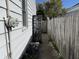 Side yard view featuring a narrow walkway, fenced boundary, and the home's white exterior at 1952 N Colorado Ave, Indianapolis, IN 46218