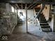 Unfinished basement with concrete floors, exposed beams, and a metal staircase at 2148 Singleton St, Indianapolis, IN 46203