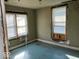 Bedroom with two windows and pale green walls with blue painted floors needing renovation at 2148 Singleton St, Indianapolis, IN 46203