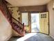 Interior entryway with a red wooden staircase and view of the yellow front door at 2148 Singleton St, Indianapolis, IN 46203