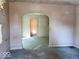 Unfurnished living room featuring an arched doorway, pale pink walls, and light blue floors at 2148 Singleton St, Indianapolis, IN 46203