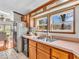 Sunlit kitchen features wood cabinetry, stainless steel sink, and views to the backyard at 25249 State Road 13 N, Noblesville, IN 46060