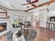 Inviting living room with a stone fireplace, ceiling fan, comfortable seating, and plenty of natural light at 25249 State Road 13 N, Noblesville, IN 46060