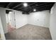 View of an open basement room with neutral carpet, white walls, and a black open ceiling at 2528 E 17Th St, Indianapolis, IN 46218