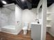 View of bathroom featuring vanity, toilet, wood-look flooring, and a tiled tub with shower at 2528 E 17Th St, Indianapolis, IN 46218
