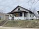Charming bungalow showcasing a quaint porch, complemented by fresh white paint and a bright yellow front door at 2528 E 17Th St, Indianapolis, IN 46218