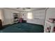 Spacious bedroom with green carpet, white walls, shelving, and a bright window at 3002 W 53Rd St, Anderson, IN 46011