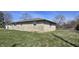 Side view of a stone house, showcasing the well-maintained yard and exterior details at 3002 W 53Rd St, Anderson, IN 46011