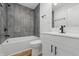 Updated bathroom with a tiled shower over tub, modern vanity, and black hardware at 3105 N Tacoma Ave, Indianapolis, IN 46218