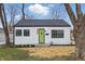 Charming home featuring a new roof, fresh white siding, black trim and a bright green front door at 3105 N Tacoma Ave, Indianapolis, IN 46218