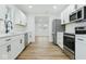 Modern kitchen with white cabinets, stainless steel appliances, and wood-look flooring at 3105 N Tacoma Ave, Indianapolis, IN 46218