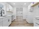Modern kitchen featuring new white cabinets, white quartz countertops, stainless faucet, and new wood flooring at 3105 N Tacoma Ave, Indianapolis, IN 46218
