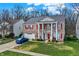 Inviting brick home with red shutters, white columns, and a well-manicured lawn with a car in the driveway at 320 Legacy Blvd, Greenwood, IN 46143