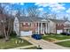 Beautiful brick home with red shutters and white columns, complimented by a well-kept lawn and blue car in the driveway at 320 Legacy Blvd, Greenwood, IN 46143