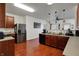 Open kitchen with stainless steel refrigerator, ample counter space, and stylish wood flooring at 320 Legacy Blvd, Greenwood, IN 46143