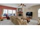 Inviting living room featuring a fireplace, ceiling fan, and natural light from the windows at 320 Legacy Blvd, Greenwood, IN 46143