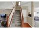 Traditional staircase with carpeted steps and wooden handrail, bathed in natural light at 320 Legacy Blvd, Greenwood, IN 46143