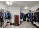 A large, organized walk-in closet with hanging clothes, shelves and a ceiling fan at 320 Legacy Blvd, Greenwood, IN 46143