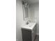 This bathroom features a gray vanity, modern fixtures, a white sink, and a decorative mirror at 3323 E 36Th St, Indianapolis, IN 46218