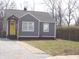 Charming home featuring a yellow door and gray siding and a well maintained landscape at 3323 E 36Th St, Indianapolis, IN 46218