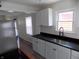 Modern kitchen featuring stainless steel appliances, black countertops, and view to the living room at 3323 E 36Th St, Indianapolis, IN 46218