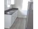 Modern kitchen featuring white cabinetry, stainless steel appliances, and gray laminate flooring at 3323 E 36Th St, Indianapolis, IN 46218