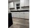 The kitchen features white cabinets, black countertops and modern floors at 3323 E 36Th St, Indianapolis, IN 46218