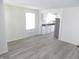 Open-concept living area showcasing the gray laminate flooring, kitchen, and window at 3323 E 36Th St, Indianapolis, IN 46218