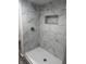 Modern tiled shower stall with built-in shelf and elegant fixtures at 3323 E 36Th St, Indianapolis, IN 46218