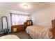 Bedroom with hardwood floors, patterned curtains, two dressers, and a mirror at 3420 N Chester Ave, Indianapolis, IN 46218