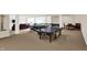 Spacious finished basement featuring a pool table, ping pong table, seating and wet bar for recreation at 3715 Kendall Wood Dr, Carmel, IN 46032