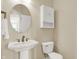 Charming powder room with a pedestal sink, oval mirror, and ample natural light at 3715 Kendall Wood Dr, Carmel, IN 46032