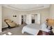 Bright bedroom with a tray ceiling, carpeting, and a door leading to the ensuite bathroom at 3715 Kendall Wood Dr, Carmel, IN 46032