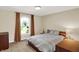 Cozy bedroom with a large window, warm wood furniture, and soft neutral bedding at 3715 Kendall Wood Dr, Carmel, IN 46032