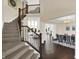 Grand foyer view with staircase and railing, hardwood floors, high ceilings, and open access to the dining and living areas at 3715 Kendall Wood Dr, Carmel, IN 46032