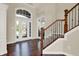 Bright foyer with hardwood floors, staircase with decorative iron railing, and a large window above the front door at 3715 Kendall Wood Dr, Carmel, IN 46032