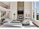 An airy living room displays a stone fireplace, built-in shelving, tall windows, and plush white seating at 3715 Kendall Wood Dr, Carmel, IN 46032