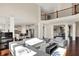Open-concept space features hardwood floors, white sofas, a black piano, and access to kitchen and dining areas at 3715 Kendall Wood Dr, Carmel, IN 46032